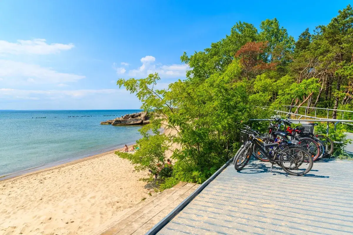 Rowery czekają na odkrycie malowniczych tras rowerowych Pomorza. Piękna plaża i spokojne morze w tle.