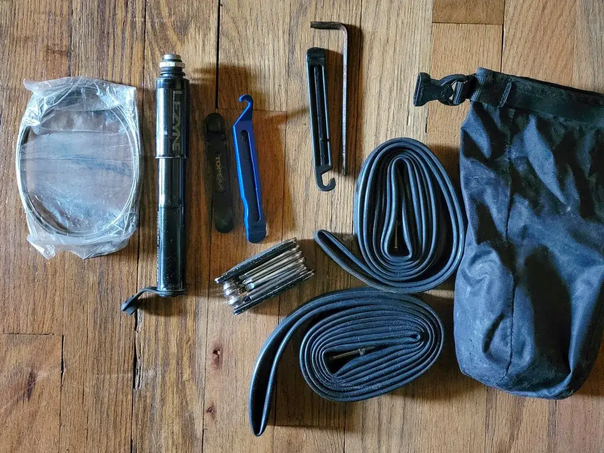 Tools for a mountain bike tune up: pump, tire levers, multi-tool, spare tubes, and a dry bag.
