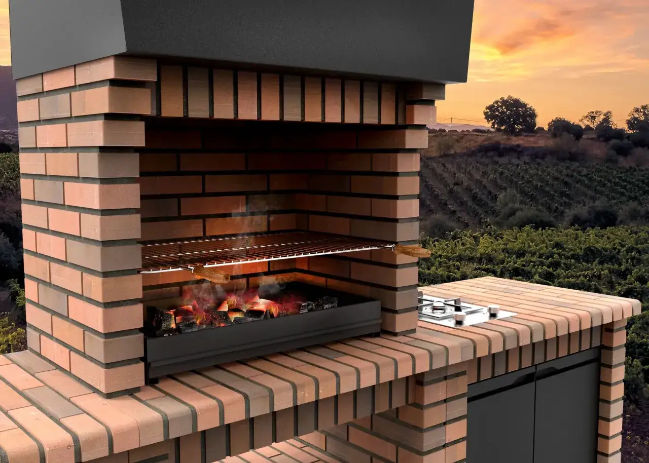 Barbacoa de obra con parrilla y brasas encendidas. Perfecta para tus ideas de barbacoa de obra en un atardecer campestre.