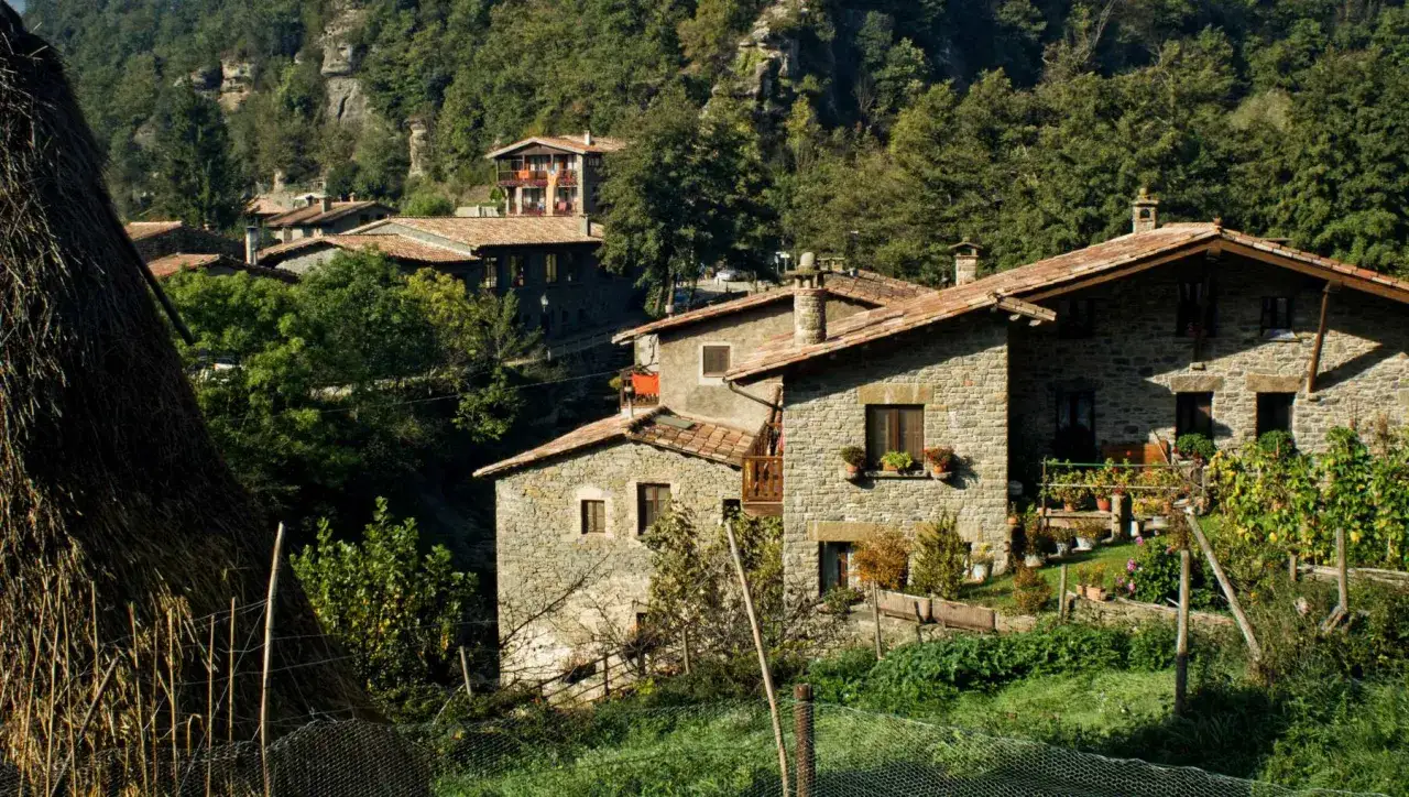 Casas de piedra en un valle verde, un ejemplo de turismo rural sostenible.