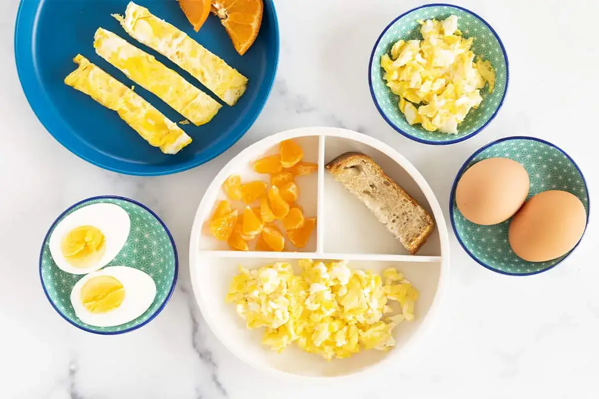 Petit-d&eacute;jeuner pour enfant : &oelig;ufs brouill&eacute;s, &oelig;ufs durs, tranches d'omelette, quartiers d'orange et pain grill&eacute;. Une recette &oelig;uf enfant facile et &eacute;quilibr&eacute;e.