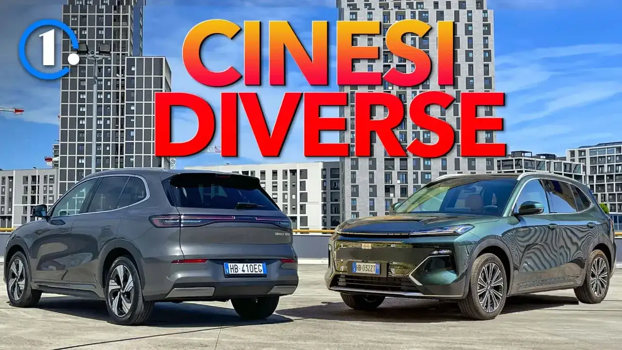 Due SUV, uno grigio e uno verde scuro, parcheggiati davanti a palazzi moderni. Il testo