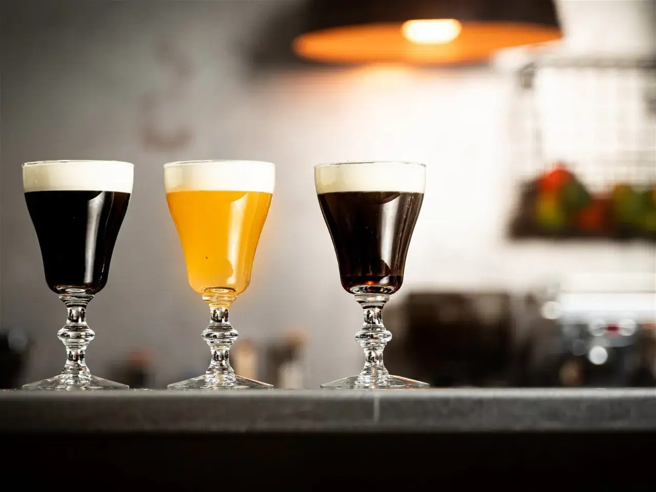 Tre glas med irish coffee, en med gyllene v&auml;tska, st&aring;r p&aring; en b&auml;nk.