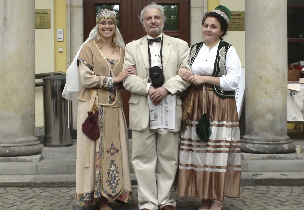 Ormianie w Polsce świętują. Trzy osoby w tradycyjnych strojach pozują do zdjęcia przed muzeum.