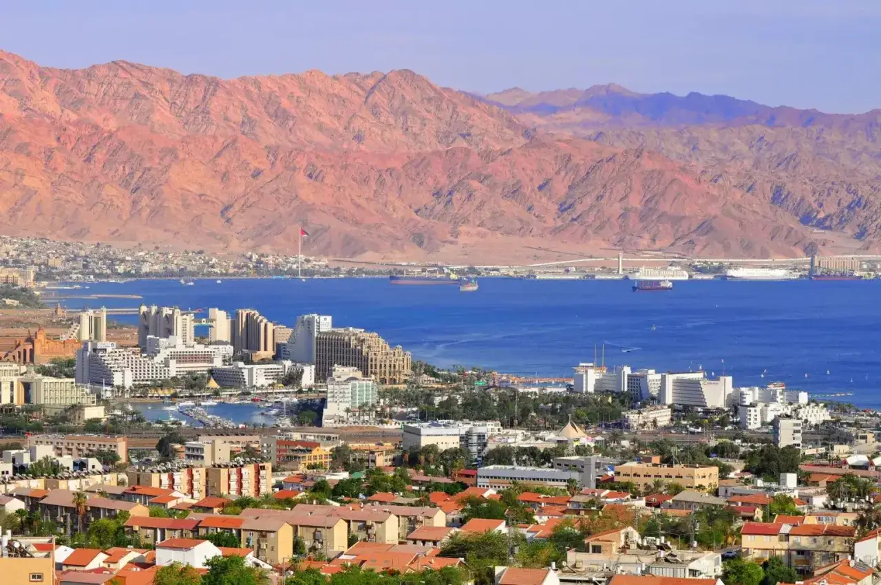 Widok na Eilat, Izrael, z czerwonymi górami w tle. Idealne miejsce na wycieczkę do Izraela, z portem pełnym łodzi i hotelami nad morzem.