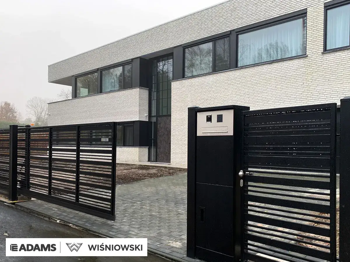 Nowoczesna, czarna brama do ogrodzenia panelowego, idealnie komponuje się z minimalistyczną architekturą domu.