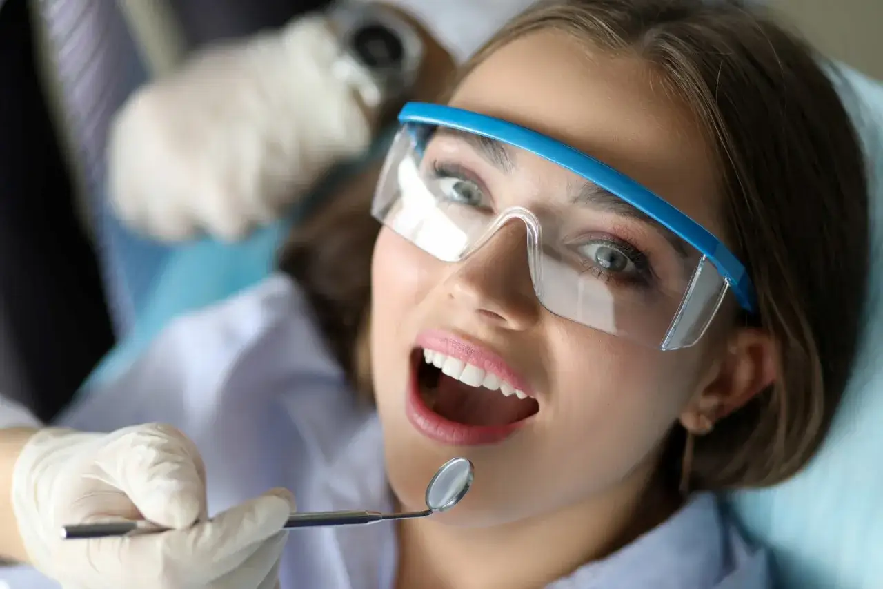 Pacjentka u dentysty, zastanawia się, czy paradontoza jest dziedziczna. Lekarz bada jej zęby.