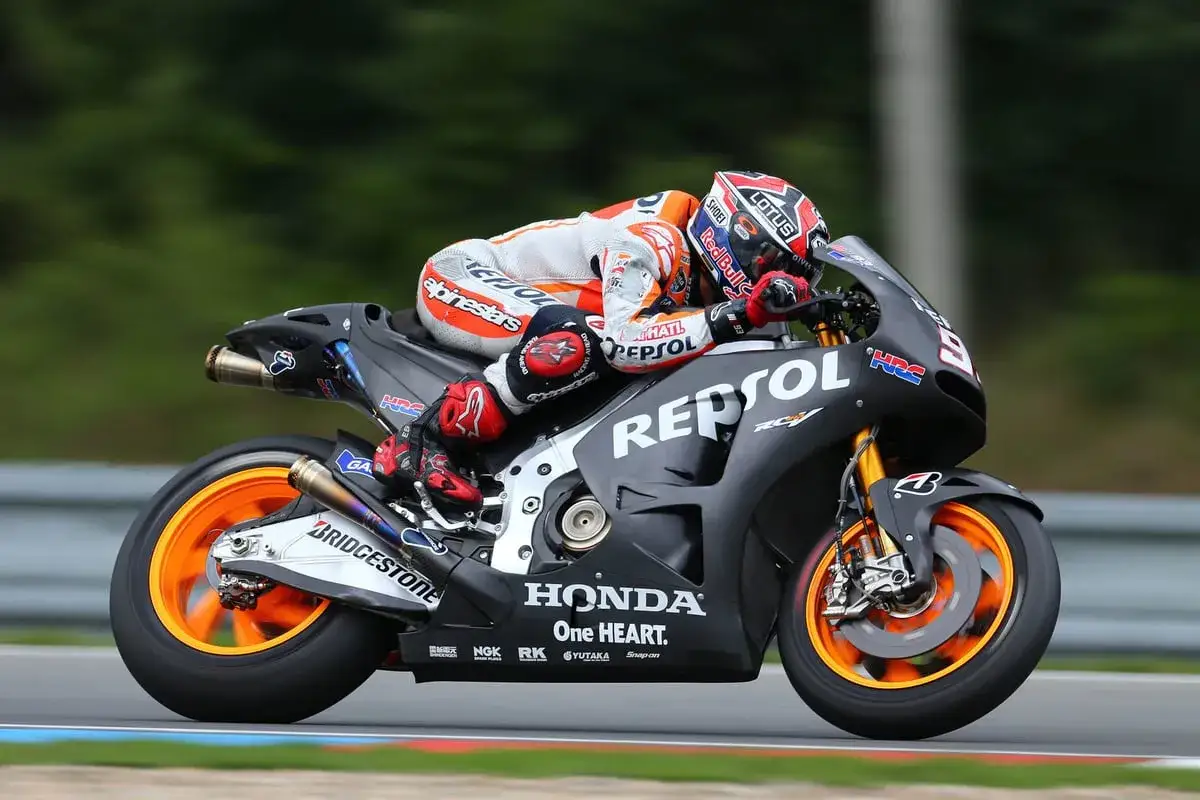 Pilotos Honda MotoGP en acci&oacute;n, inclinados en una curva con su moto Repsol.