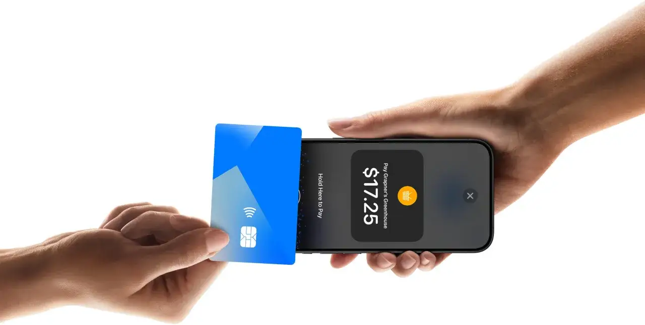 Osoba trzymająca iPhone'a z komunikatem o błędzie płatności na ekranie terminala