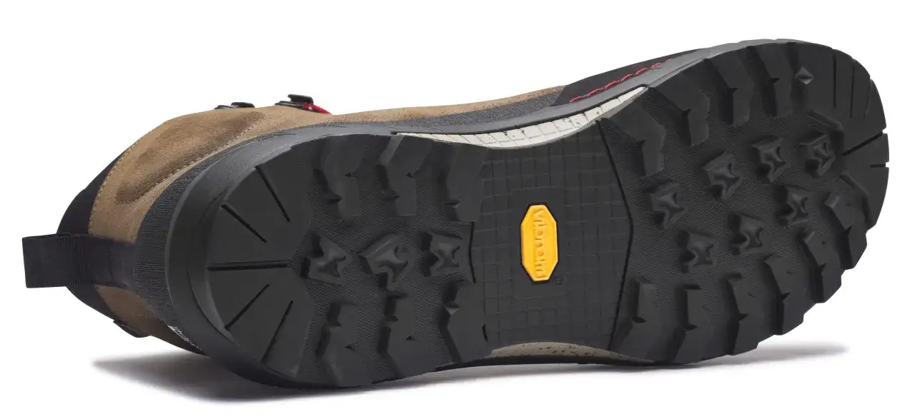 Semelle Vibram : c'est quoi ? La semelle extérieure crantée d'une chaussure de randonnée marron, avec le logo jaune Vibram bien visible.