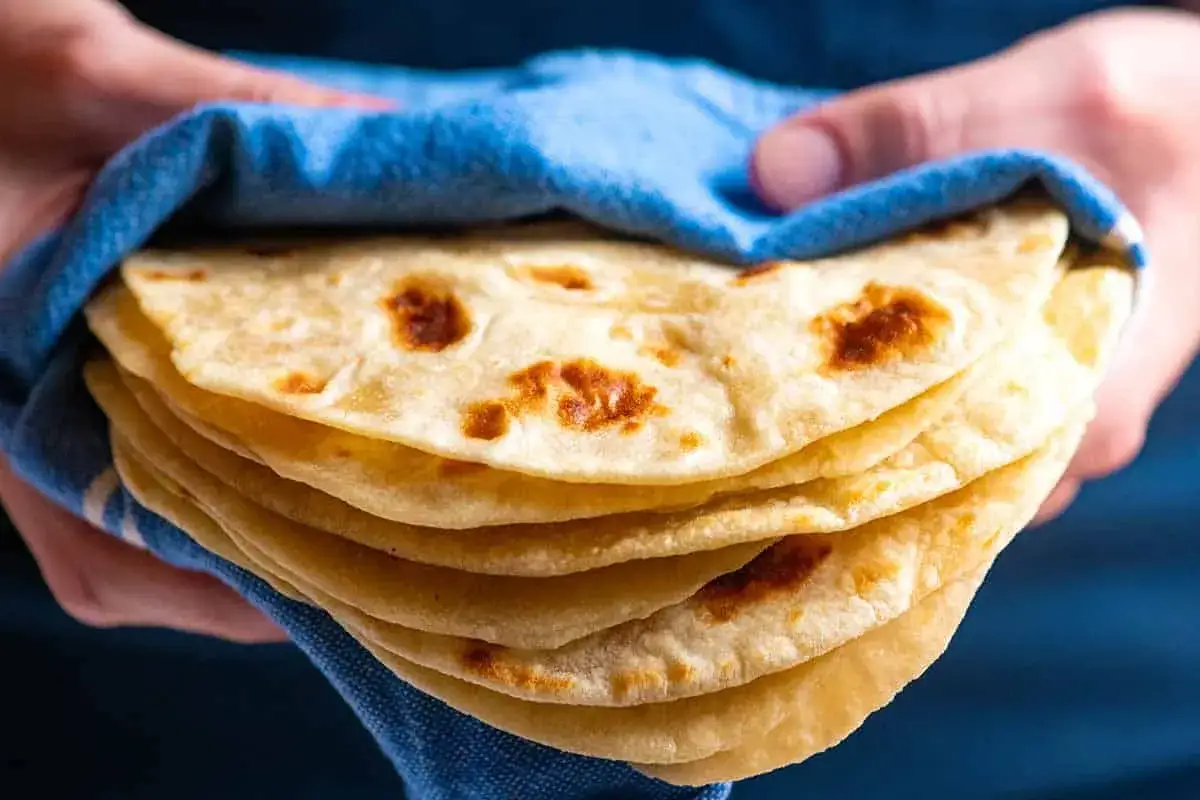 Stos świeżo upieczonych, puszystych tortilli, idealnych do każdego dania. To najlepsza tortilla przepis, jaki kiedykolwiek wypróbujesz!