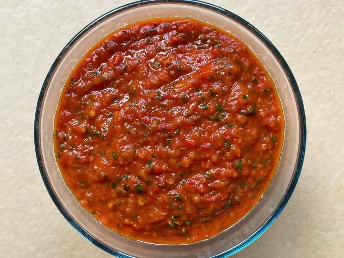 Bagnetto rosso piemontese in una ciotola di vetro, un condimento saporito e piccante, perfetto per accompagnare bolliti e carni.