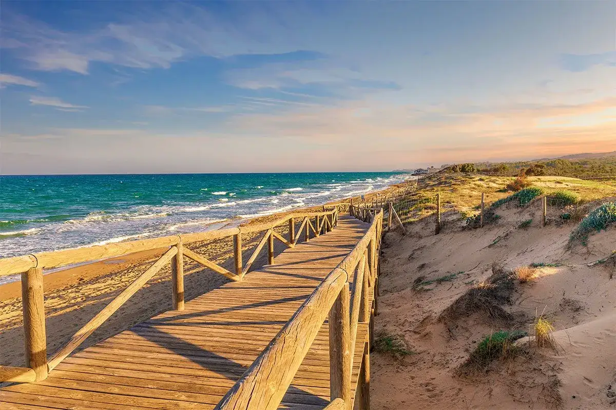 Drewniana kładka prowadzi na piaszczystą plażę nad turkusowym morzem. Idealne miejsce, by poczuć słońce i fale. Alicante co zobaczyć? To właśnie!
