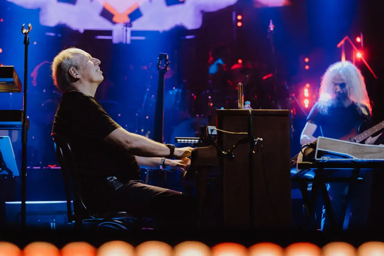 Hans Zimmer gra na pianinie, a jego zespół towarzyszy mu na scenie. Koncert trwa, a widzowie są zachwyceni.