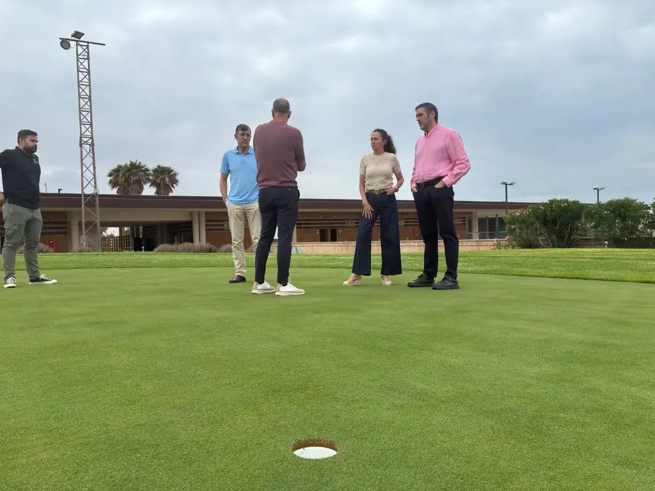 Un grupo de personas discute en un campo de golf en Almería. El toyo, un ave, podría estar observando desde lejos.