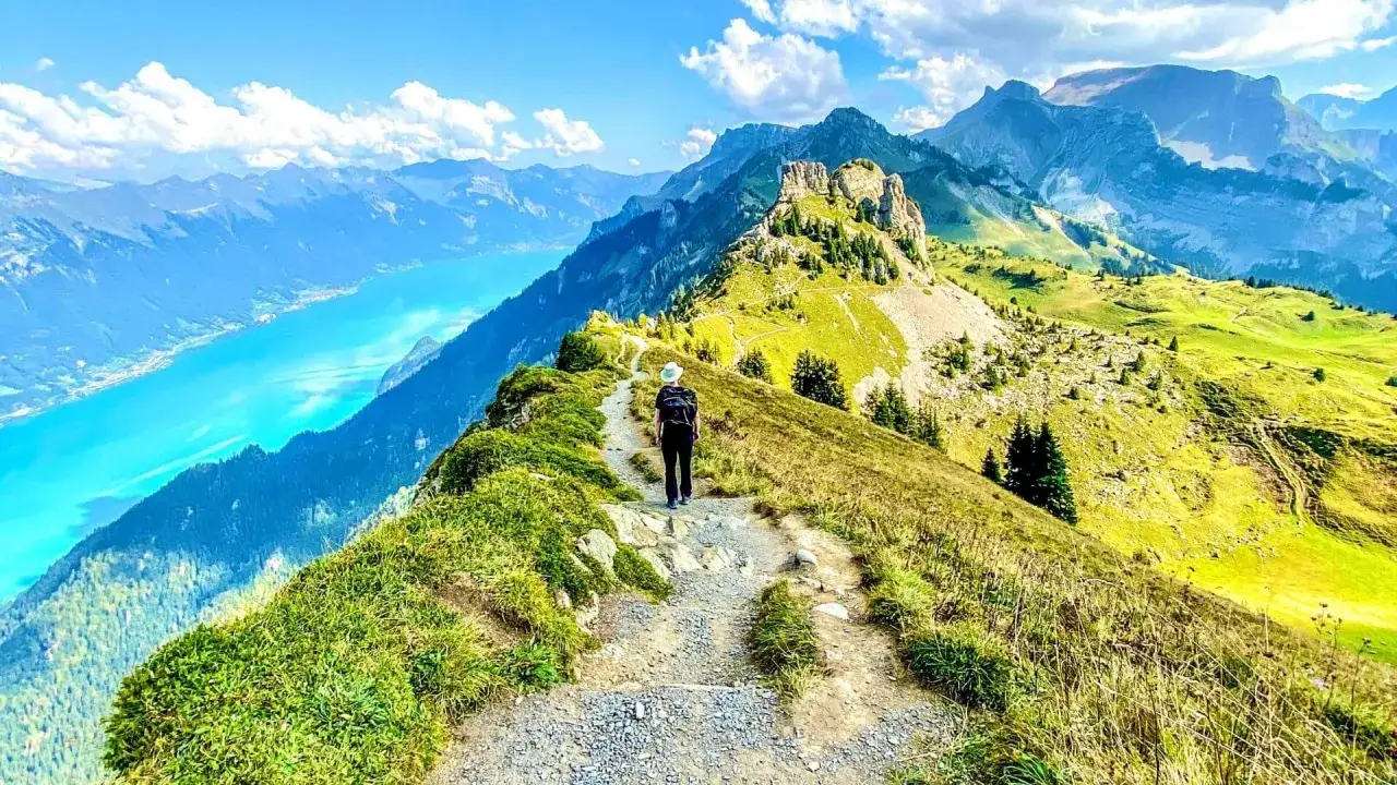 Randonnée sur un sentier escarpé avec vue sur le lac et les montagnes de l'Eiger Jungfrau.