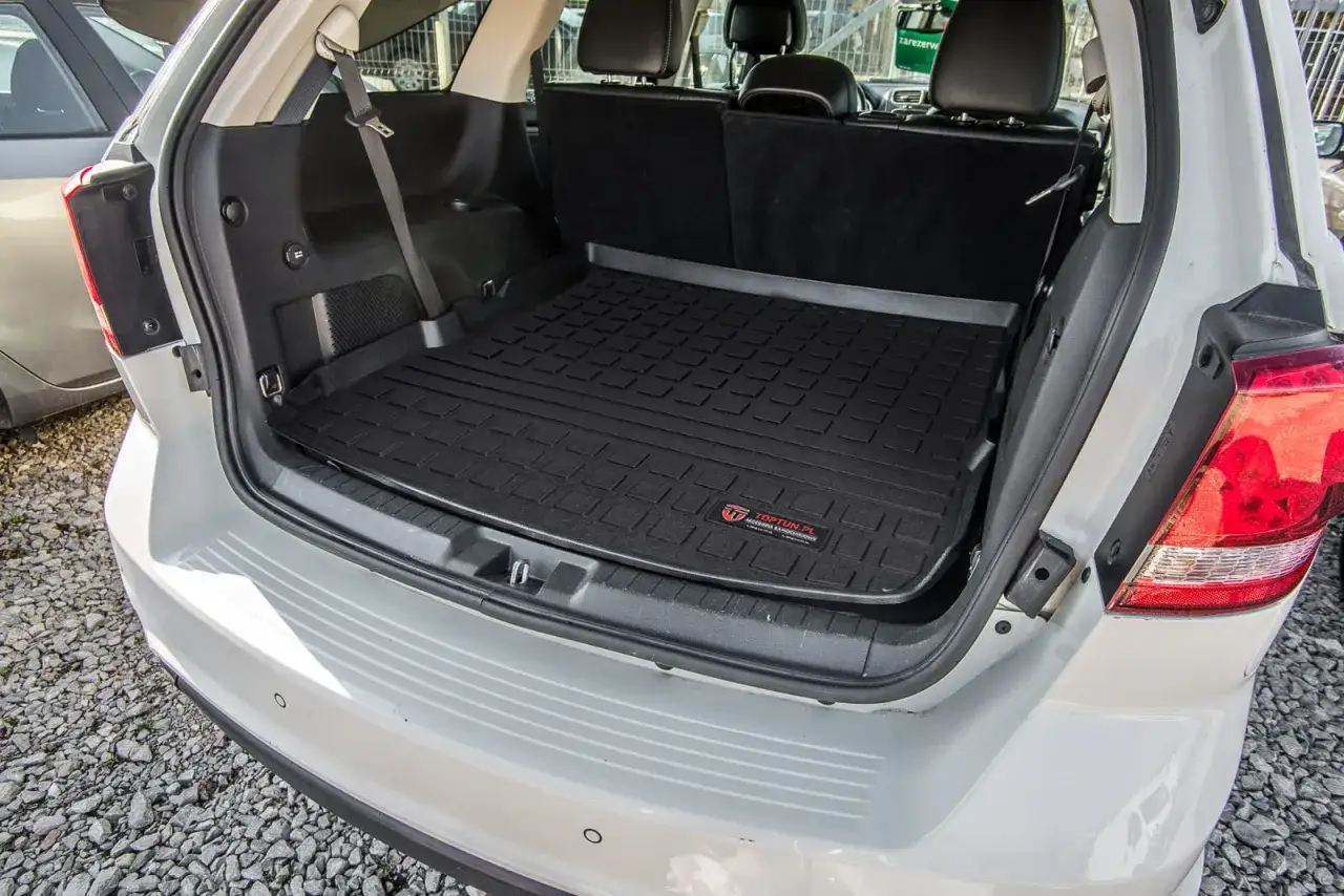Biały Dodge Journey z zamontowaną gumową matą bagażnika. Wiele osób chwali sobie takie rozwiązanie, co potwierdzają liczne dodge journey opinie.