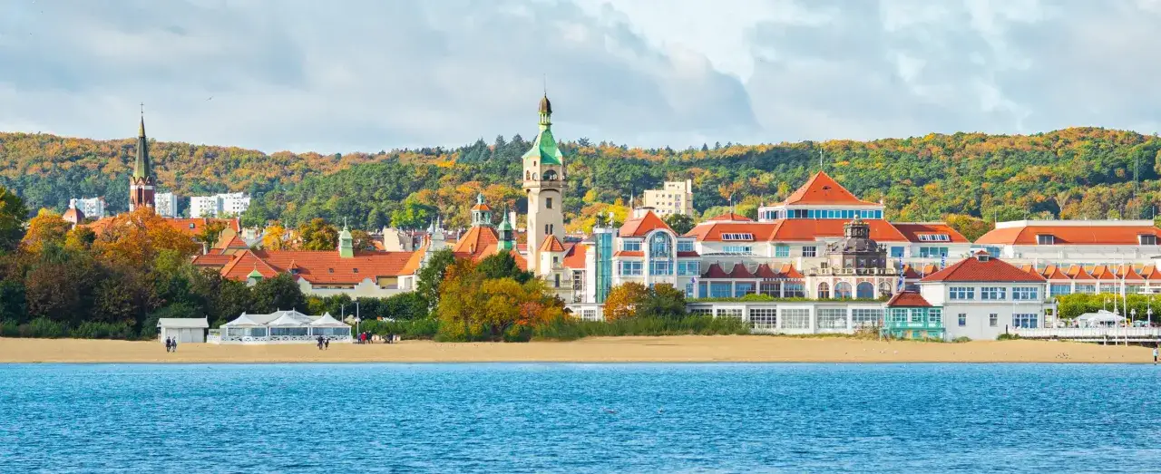 Sopot atrakcje: malowniczy widok na plażę, morze i zabytkowe budynki z charakterystyczną wieżą.