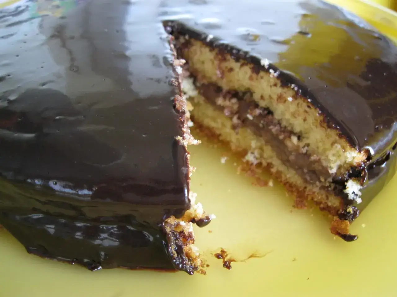 Una deliziosa torta margherita con un ripieno cremoso al cioccolato, ricoperta da una lucida glassa al cioccolato fondente.