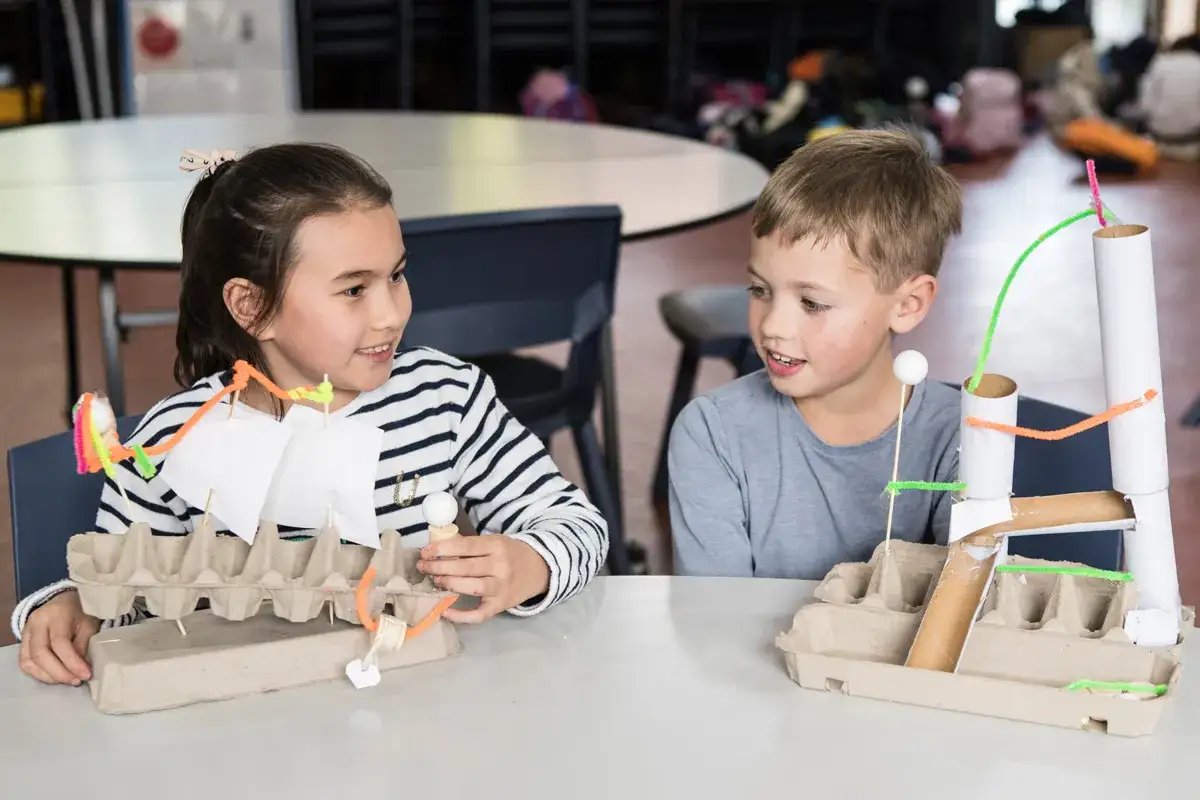 Ni&ntilde;os de 6 a 8 a&ntilde;os crean inventos con cart&oacute;n y limpiapipas: un barco y una torre.