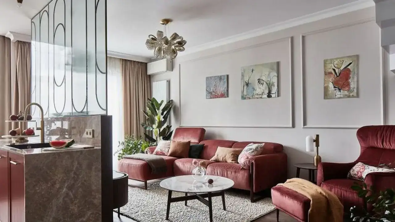 Nowoczesny salon z bordową kanapą i fotelami. Na ścianie wiszą abstrakcyjne obrazy, które są fajne pomysły na zdjęcia na ścianie.