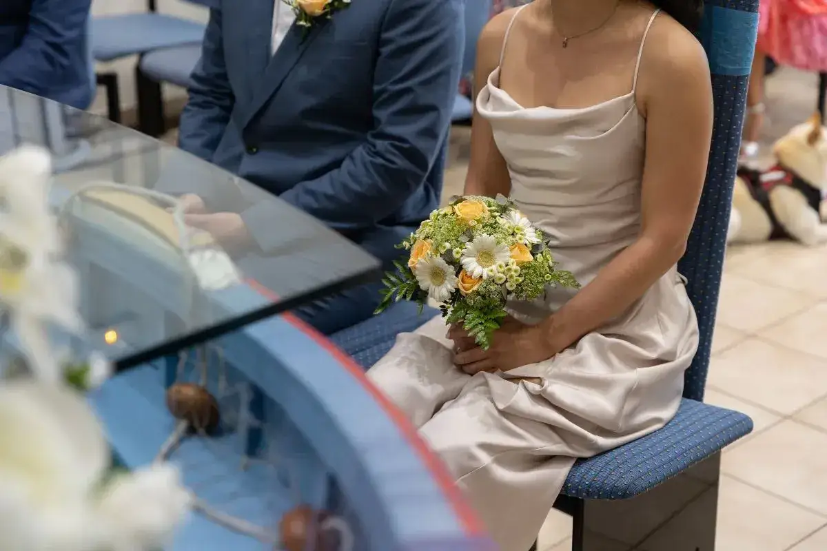 Coppia in abito da cerimonia, lei con bouquet. Il rito civile quanti testimoni? La scena &egrave; intima, forse solo i pi&ugrave; cari.