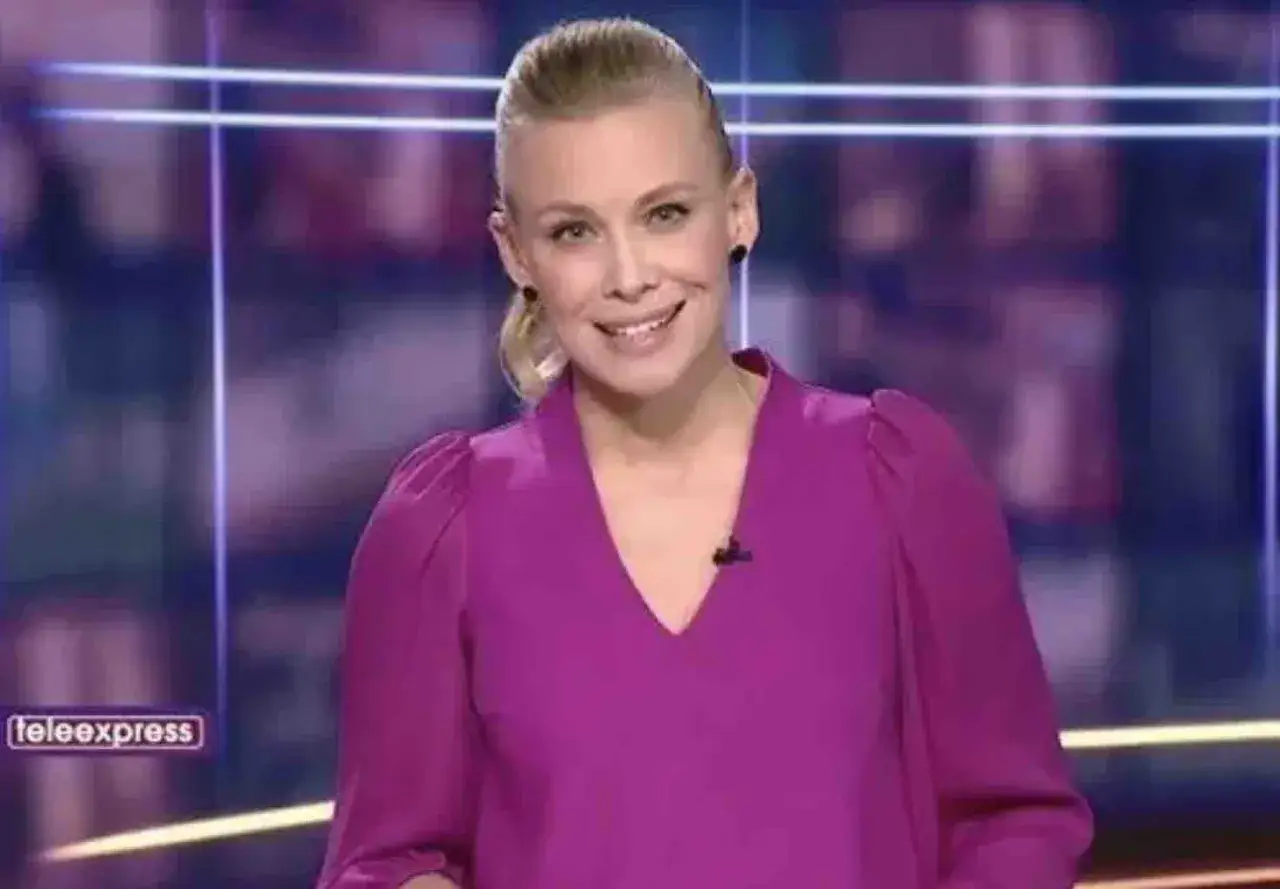 Aleksandra Kostrzewska w fioletowej bluzce, uśmiechnięta, w studiu