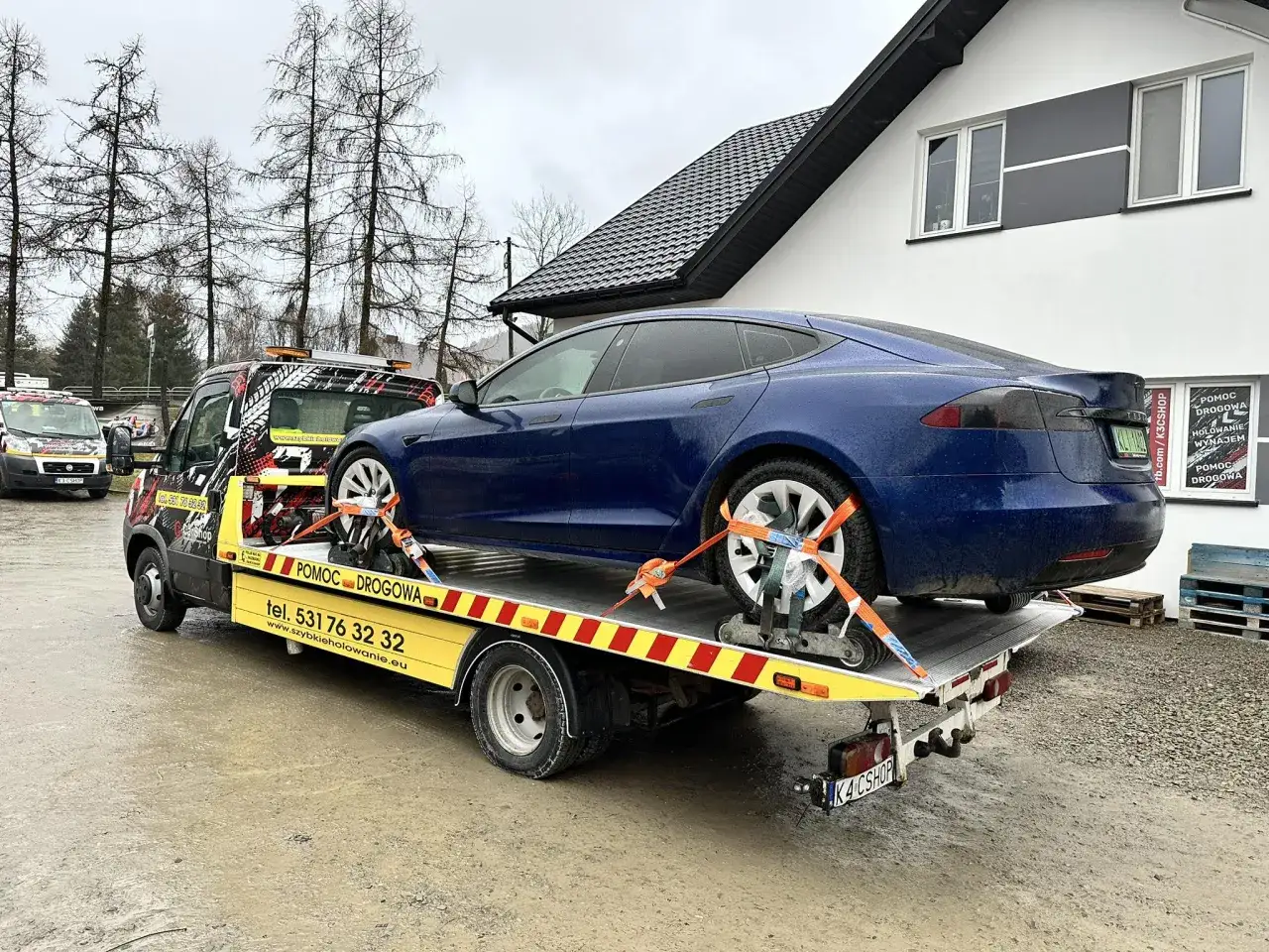 Niebieski Tesla na lawecie, gotowy na assistance krótkoterminowe 1000km. Pomoc drogowa czeka.