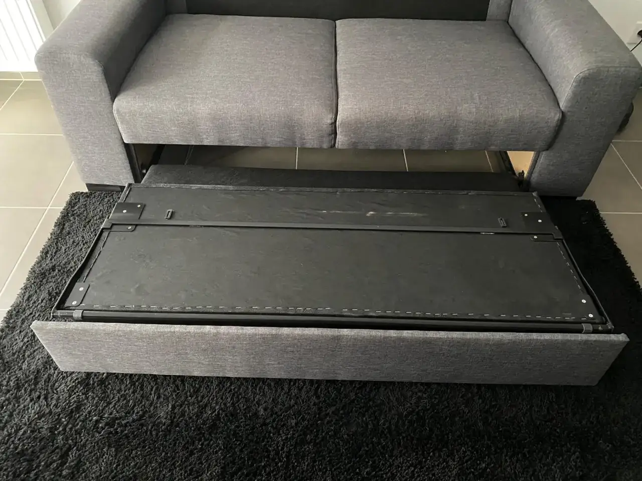Le sommier d'un canapé convertible est sorti, prêt à être remplacé.
