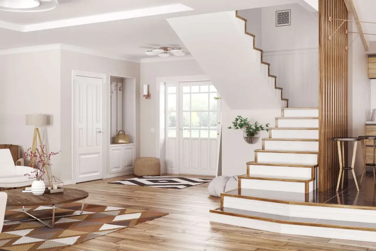 Id&eacute;e couleur cage escalier : un int&eacute;rieur lumineux avec un escalier blanc et bois, des portes blanches, et des tapis graphiques.