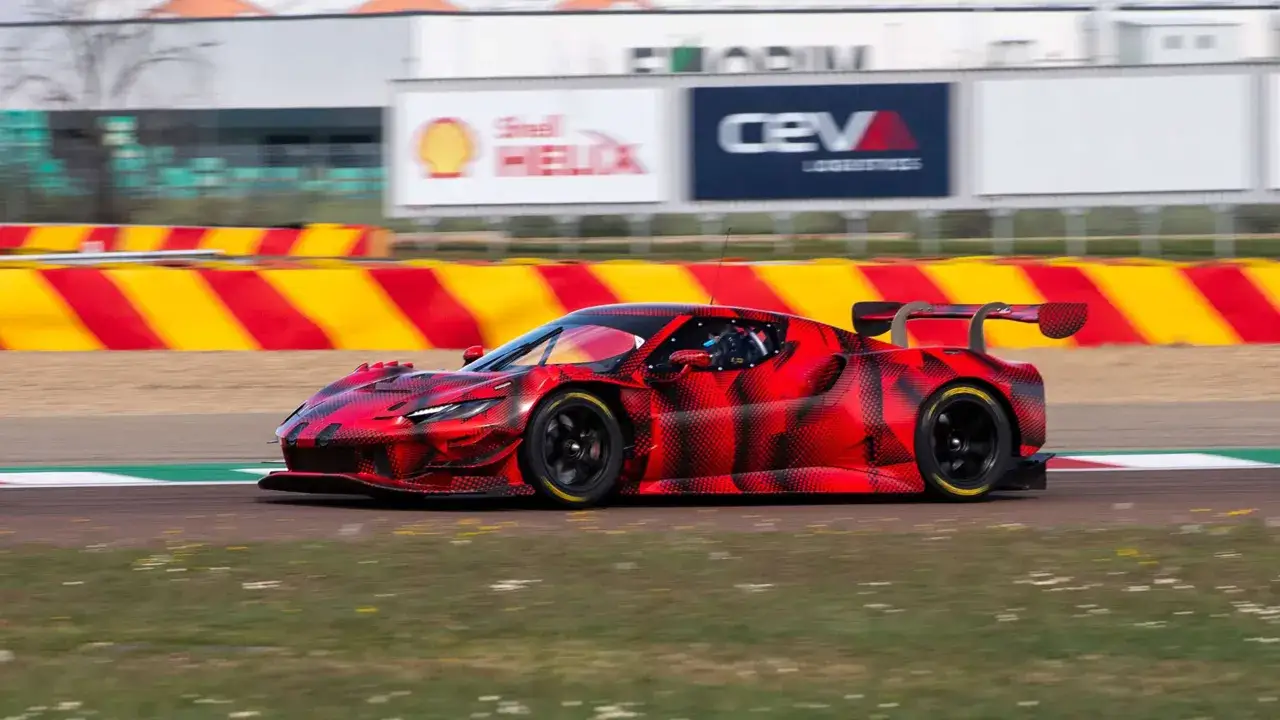 El Ferrari 296 GT3, con su camuflaje rojo y negro, acelera en la pista, listo para la competici&oacute;n.