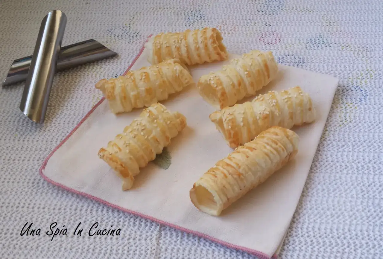 Rotolini di pasta sfoglia con semi di sesamo, pronti per essere farciti. Ideali per scoprire cosa mettere dentro la pasta sfoglia per un antipasto sfizioso.