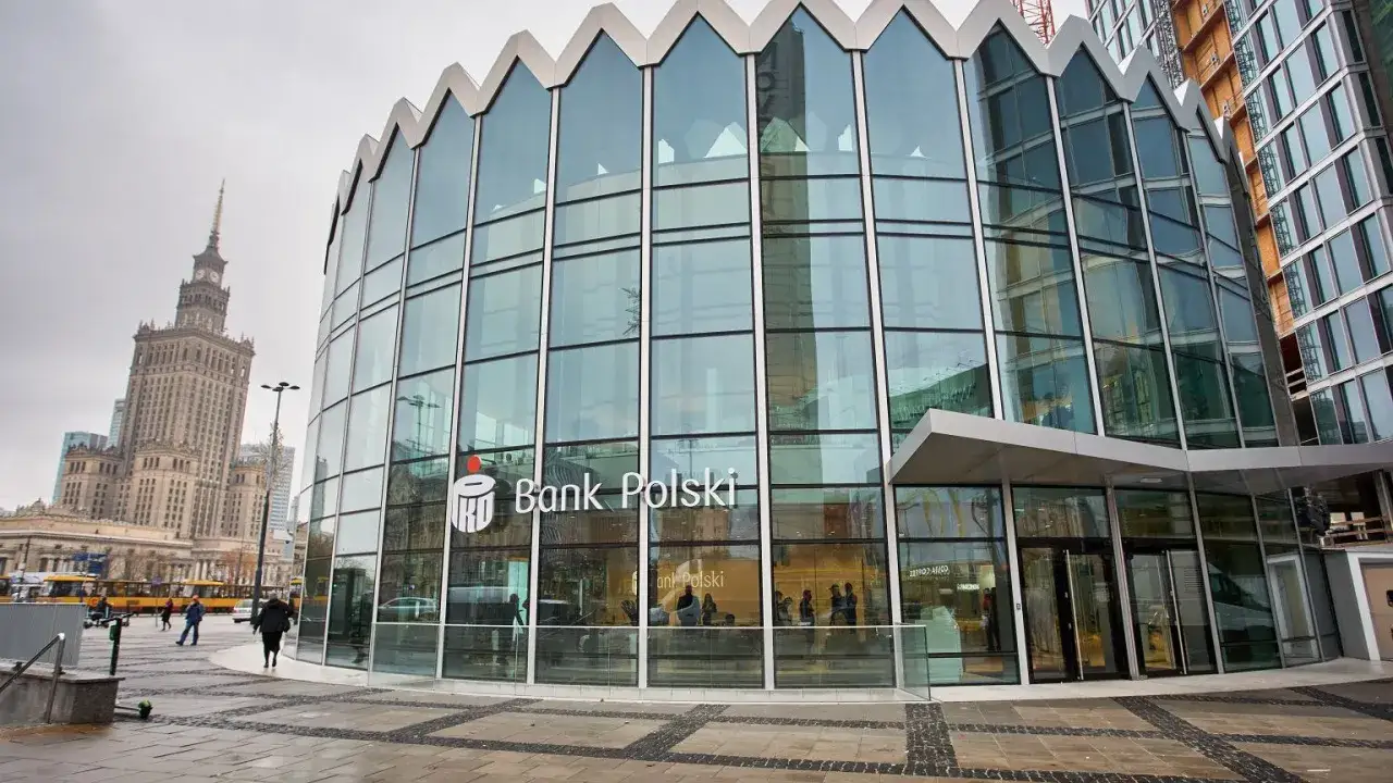 Nowoczesna budowla na planie koła z logo Banku Polskiego. W tle Pałac Kultury.