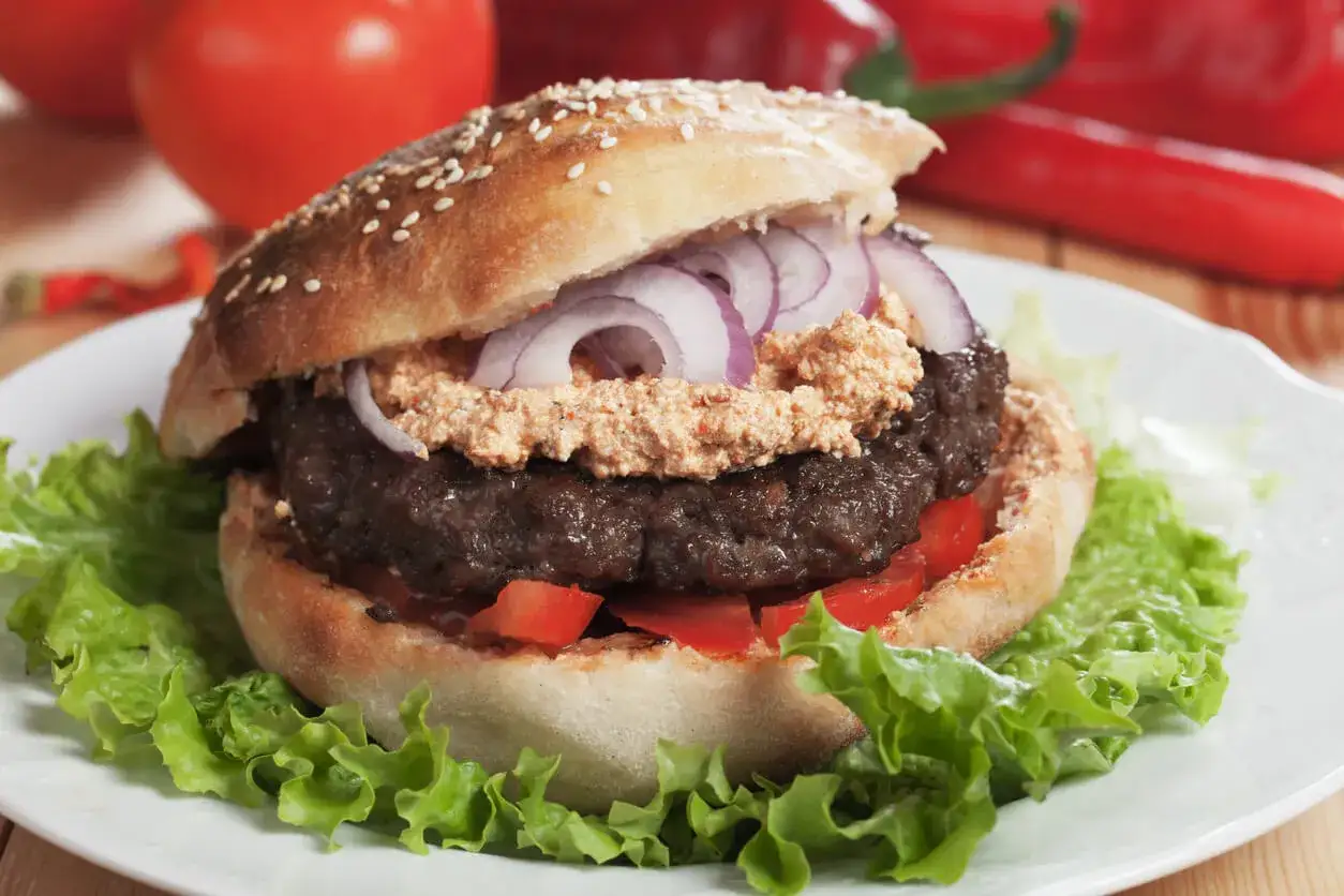 En saftig pljeskavica i ett sesambröd med lök, tomat och sallad. Ett spännande pljeskavica recept att prova!