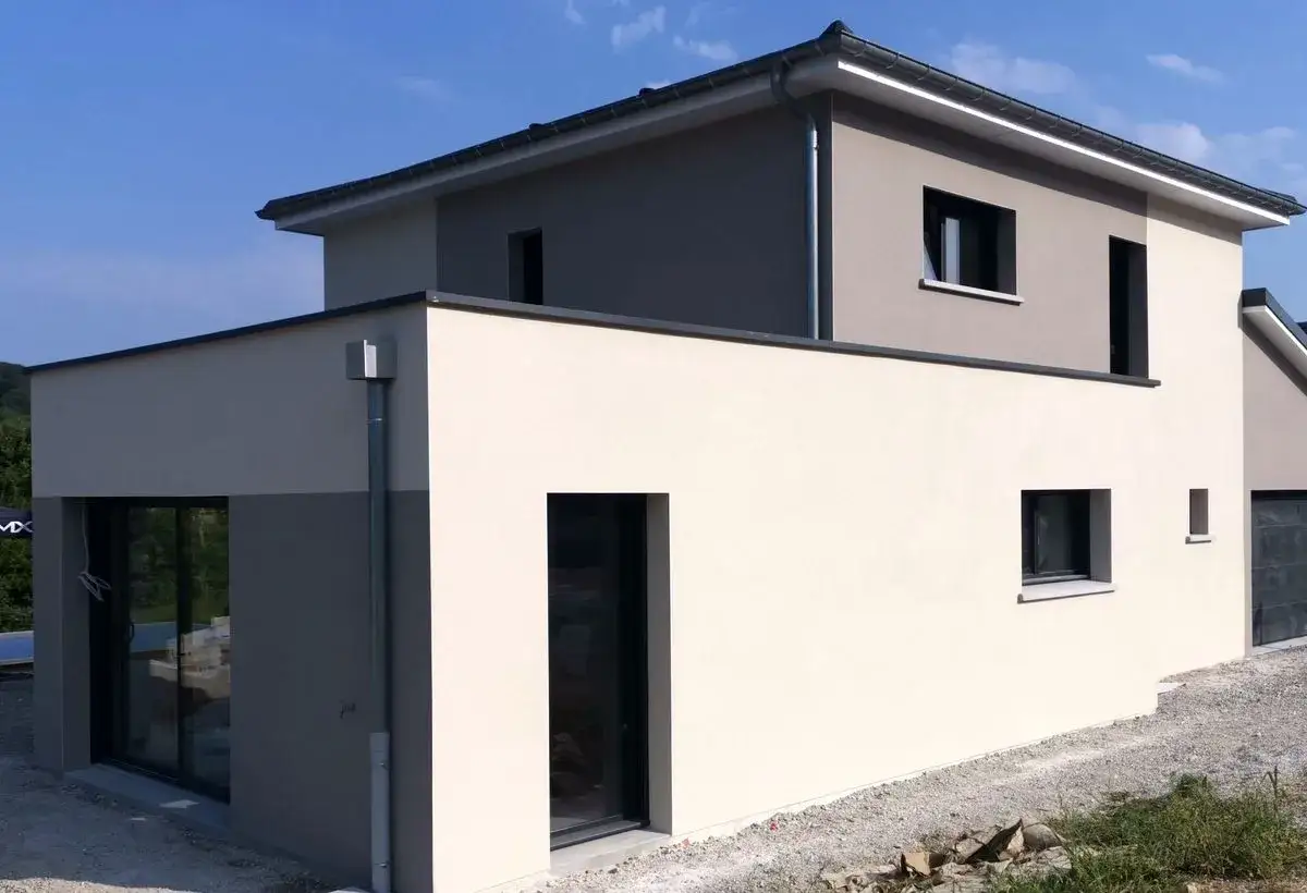 Moderne maison avec fa&ccedil;ade 2 couleurs, beige clair et gris. Grandes fen&ecirc;tres et toit plat.
