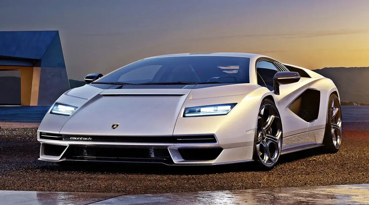 Biały Lamborghini Countach L, ikona motoryzacji, prezentuje swoje ostre linie na tle zachodzącego słońca.