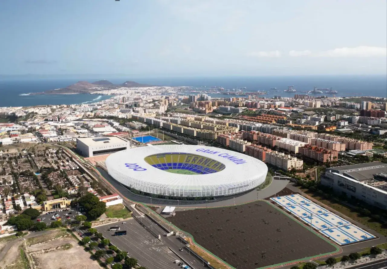 Widok z lotu ptaka na nowoczesny stadion **Estadio Gran Canaria** otoczony miastem i morzem.