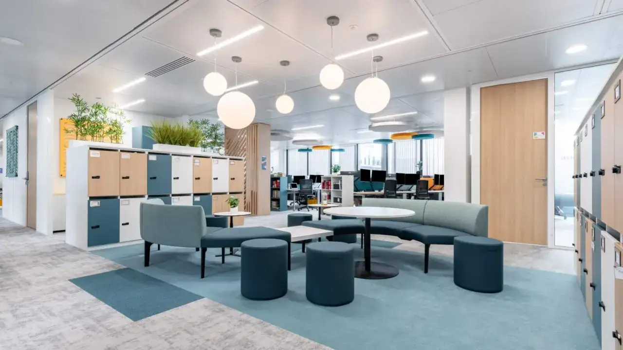 Espace de travail moderne avec casiers, si&egrave;ges modulables et tables basses, parfait pour un **flex office** dynamique.