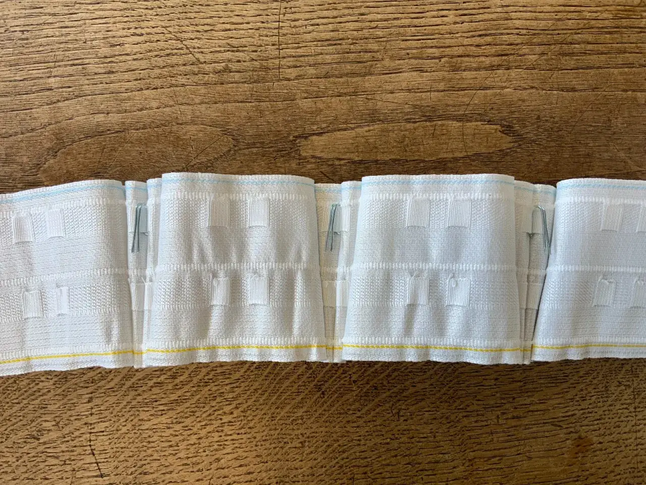 White pinch pleat curtain heading tape with hooks, ready for measuring how to measure for pinch pleat curtains.