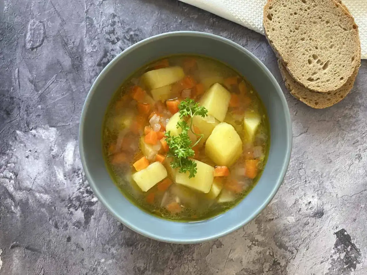 Herzhafte Kartoffelsuppe mit Karotten und Petersilie, zubereitet im Thermomix. Dazu gibt es frisches Brot.