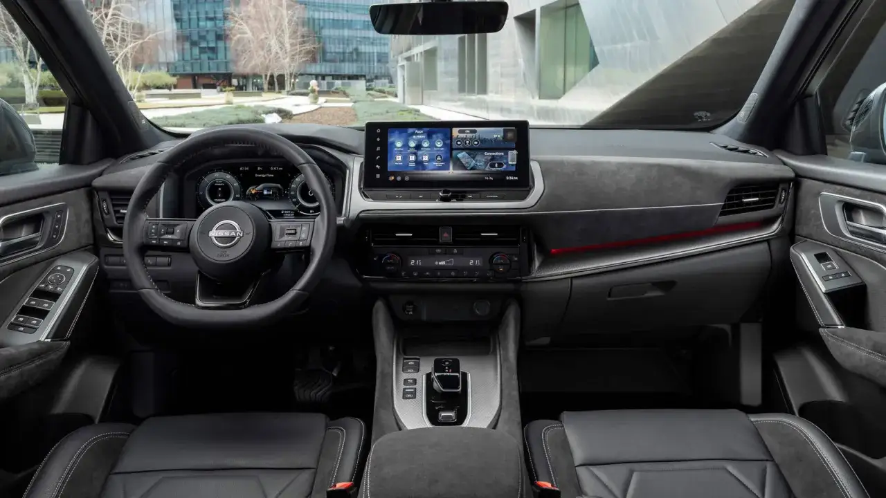 Wnętrze Nissana Qashqai z nowoczesnym ekranem multimedialnym i cyfrowymi zegarami. Sprawdź aktualną nissan qashqai cena.