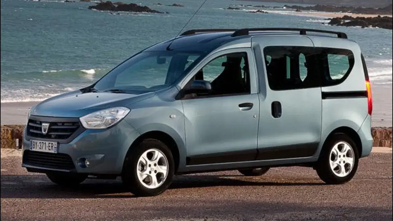 Auto blu con porte scorrevoli parcheggiata sulla costa. Ideale per avventure familiari al mare.