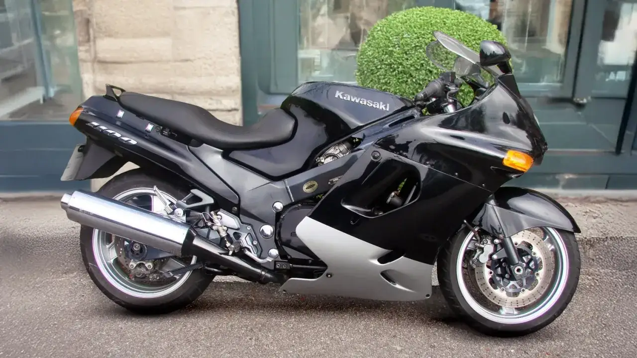 Czarny motocykl Kawasaki ZZR 1100 z błyszczącym wydechem i chromowanymi felgami, gotowy do podróży.