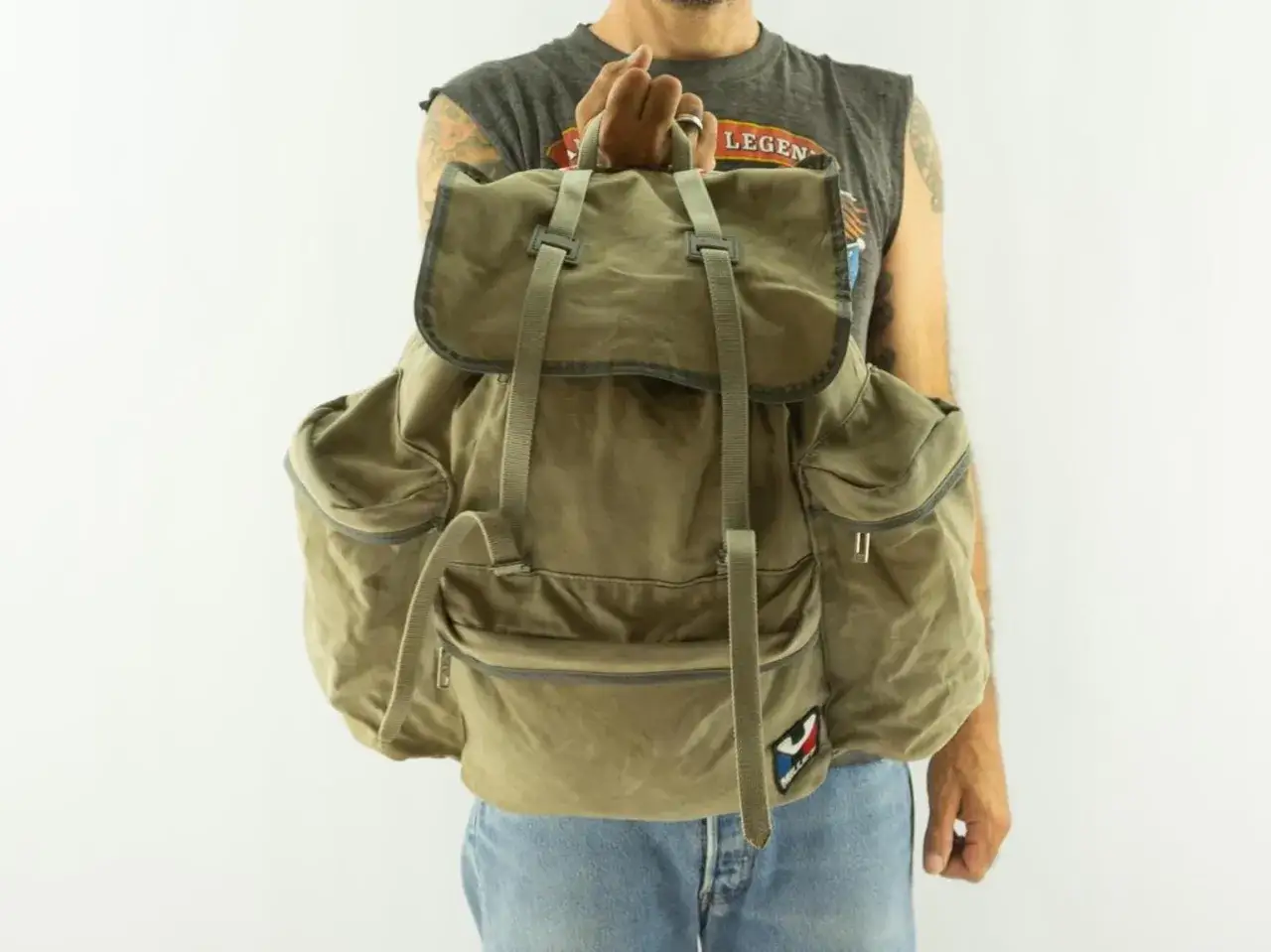 Sac à dos kaki, style vintage, rappelant les aventures du fondateur Millet.
