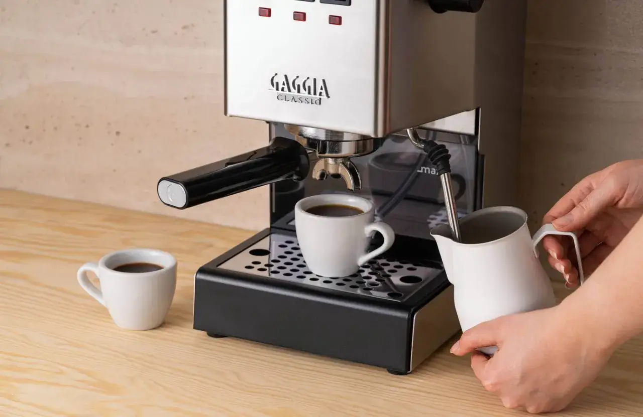 Gaggia Classic w rankingu ekspresów do kawy do 2000 zł. Parzy kawę do małej filiżanki, obok dzbanek do mleka.