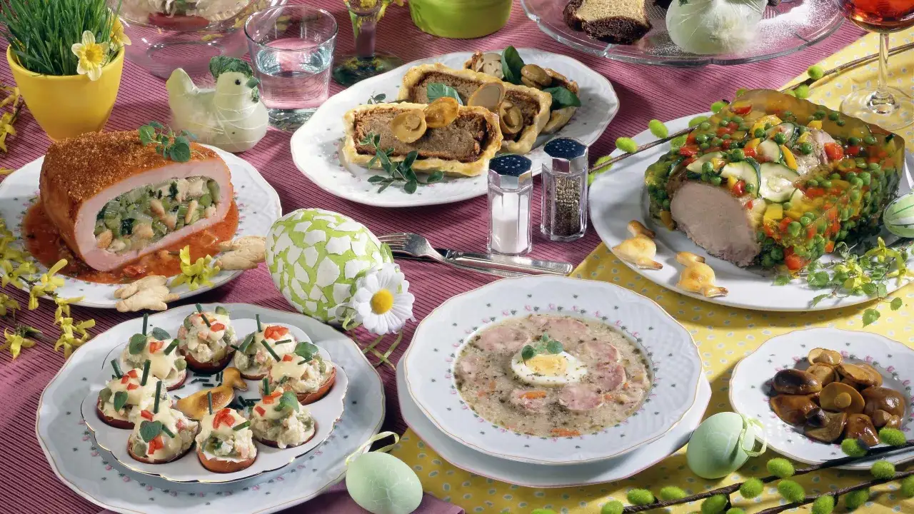 Wielkanocny stół pełen pyszności: pieczony schab, galareta z warzywami, pasztet, jajka faszerowane i żurek. Idealne inspiracje, co ugotować na święta.