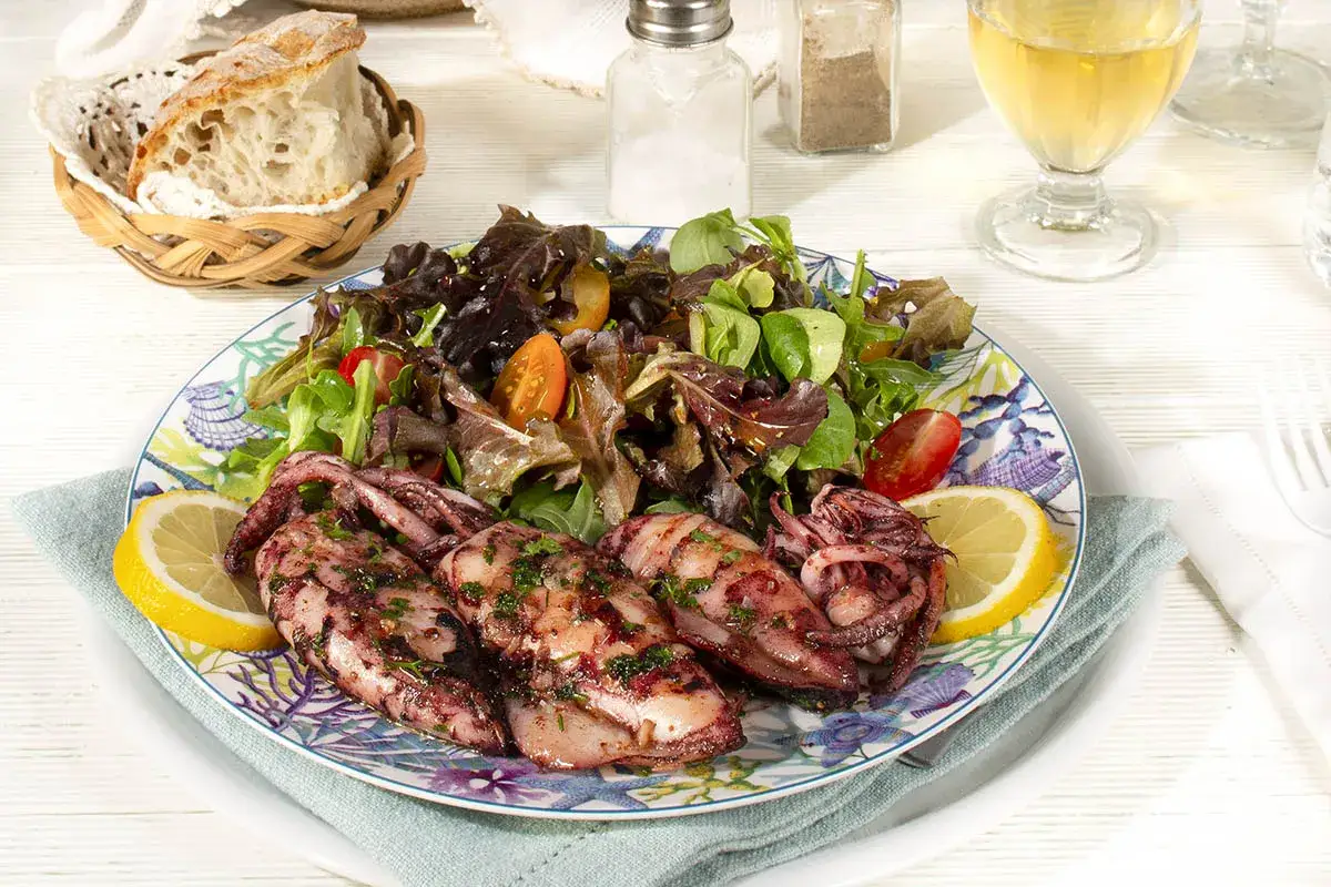 Calamares a la parrilla con ensalada fresca y limón. Una deliciosa opción para tus recetas con calamares.