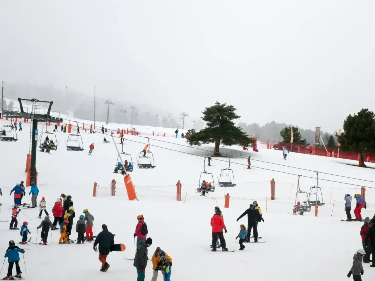 Ludzie na nartach i snowboardach korzystają z wyciągów na ośnieżonym stoku. Idealne miejsce, gdzie na narty w Europie.