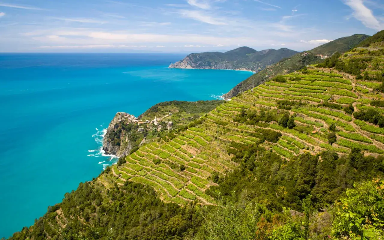 Terrazzamenti verdi scendono verso il mare turchese, un paesaggio da cartolina tra i **posti belli in Liguria sul mare**.