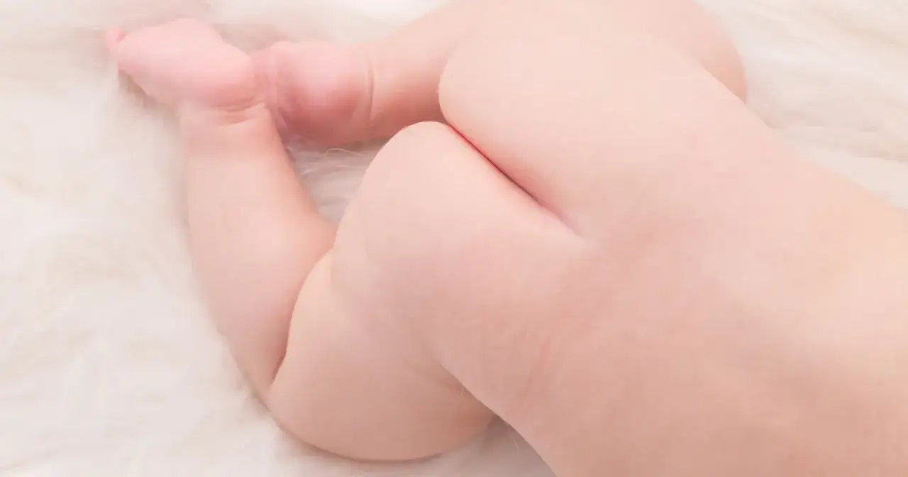 Detailaufnahme von Babypopos mit zarten Hautfalten. Ein Kleinkind hat leichte Pusteln am Po, die aber kaum sichtbar sind.